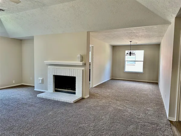 a view of a livingroom with a fireplace and window