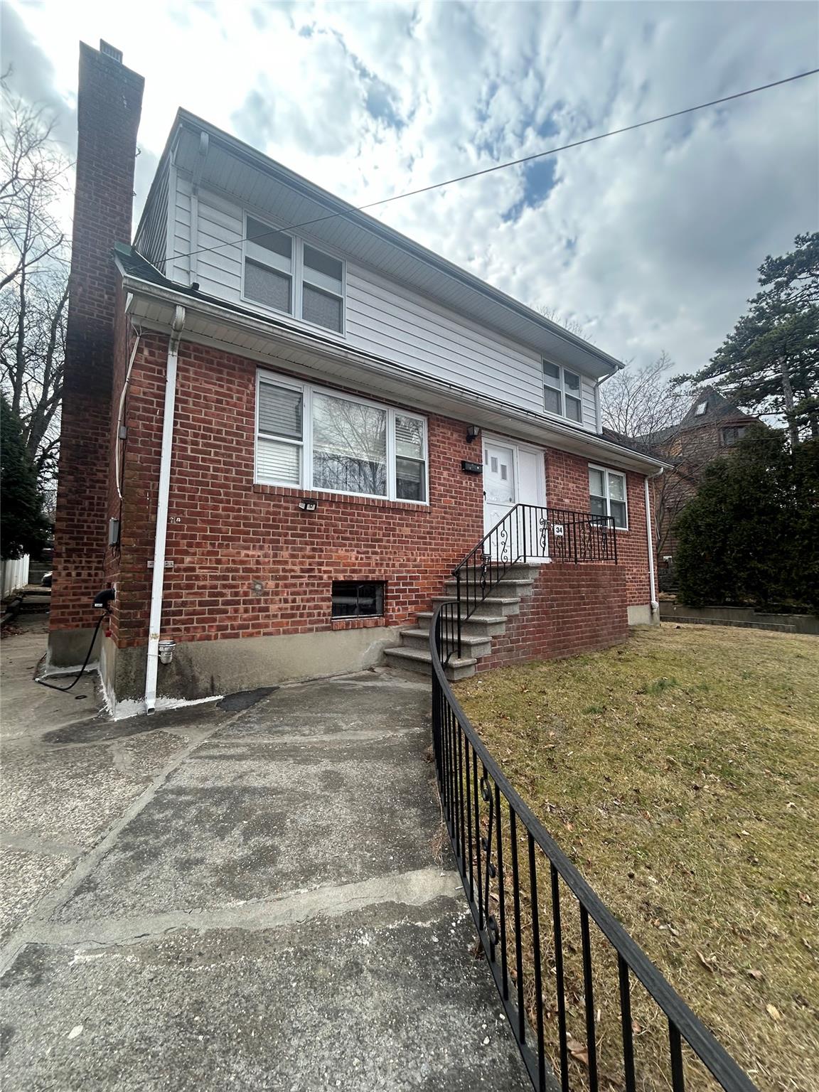 34 Belvedere Drive, Unit 2 Yonkers, NY 10705 - Photo 1 of 11 View of front of home featuring a front yard, brick siding, and a chimney