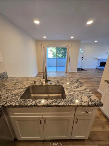 a kitchen with granite countertop a stove and cabinets