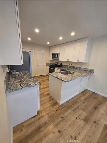 a kitchen with granite countertop stainless steel appliances and wooden cabinets
