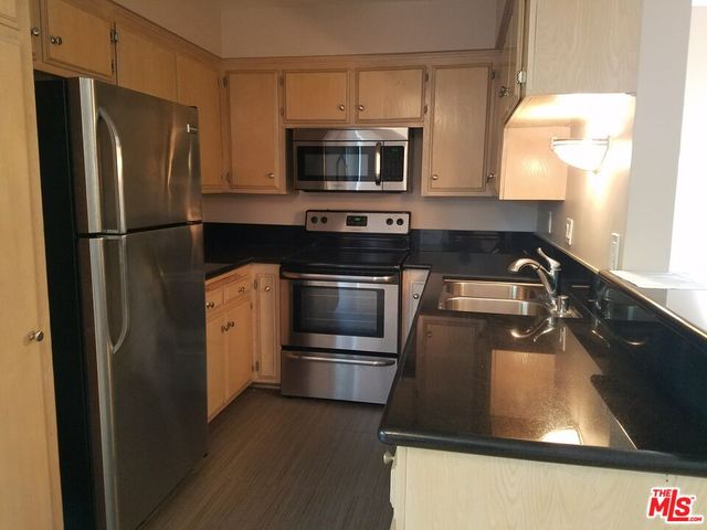 a kitchen with a sink and stainless steel appliances