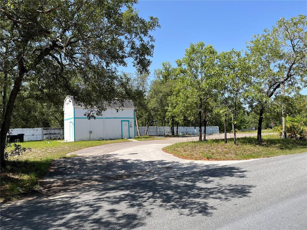 18132 Commercial Way Weeki Wachee, FL 34614 - Photo 11 of 22 a view of a backyard with large trees
