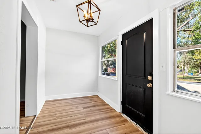 a view of a hallway with wooden floor and a window