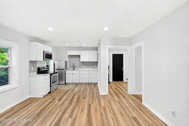 a view of kitchen with wooden floor and electronic appliances