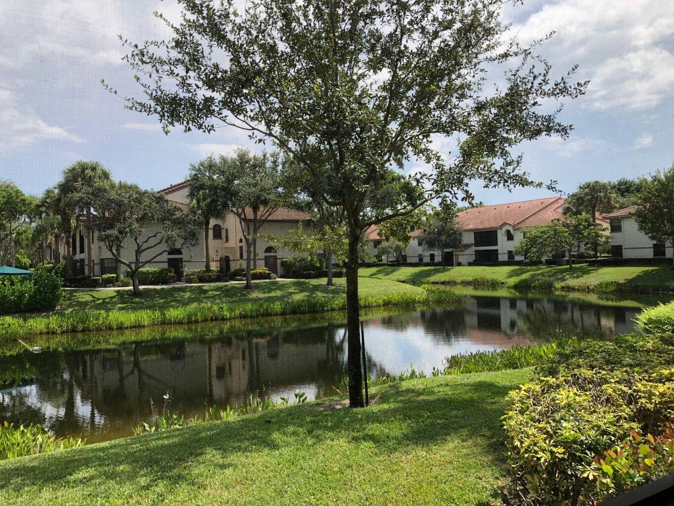 5265 Brisata Circle, Unit E Boynton Beach, FL 33437 - Photo 1 of 20 a view of a lake with a house in the background