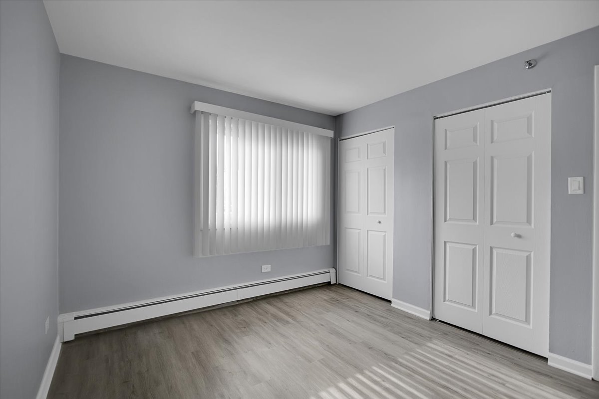 10310 Ridgeland Avenue, Unit 208 Chicago Ridge, IL 60415 - Photo 21 of 29 an empty room with wooden floor and windows