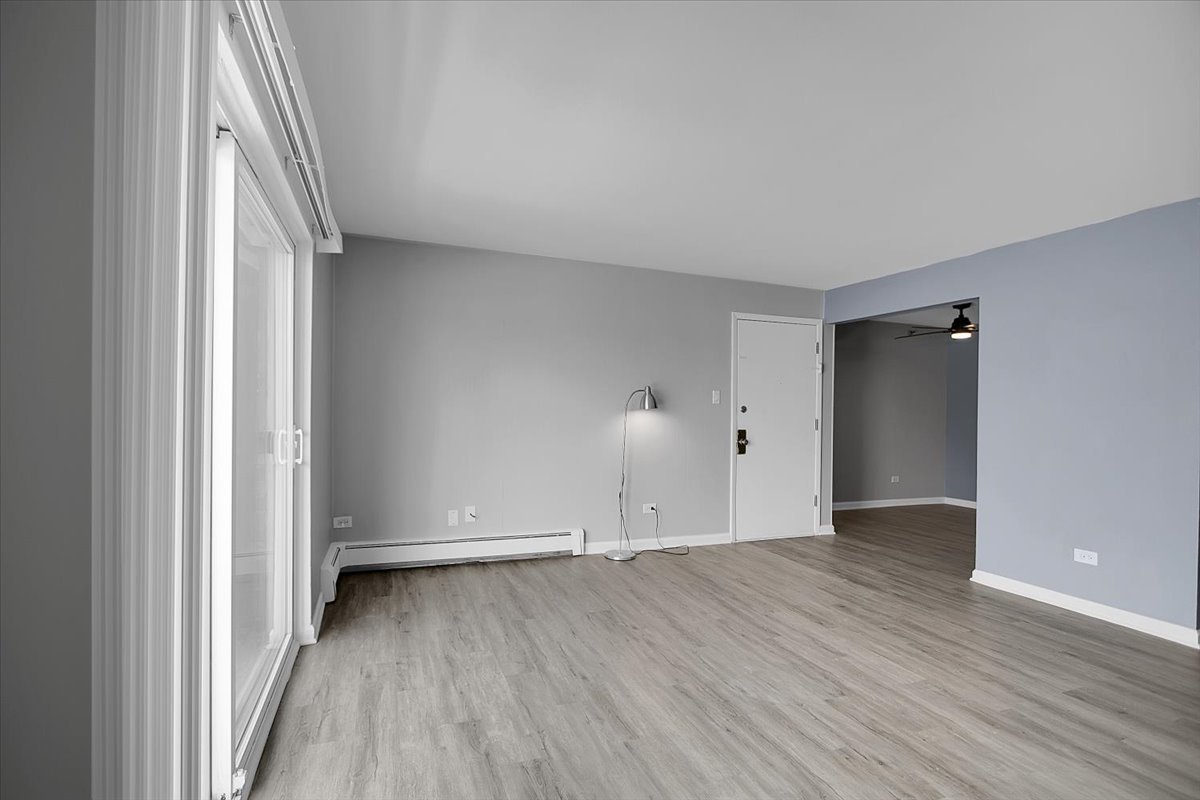 10310 Ridgeland Avenue, Unit 208 Chicago Ridge, IL 60415 - Photo 8 of 29 an empty room with wooden floor and windows