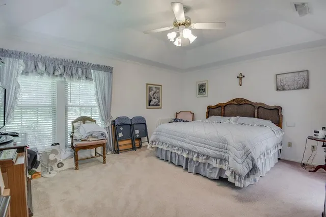 a spacious bedroom with a bed and a chandelier
