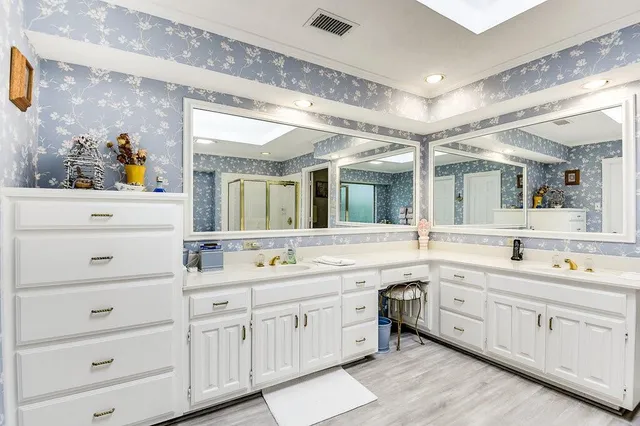 a spacious bathroom with a double vanity sink and mirror