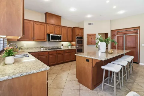 a kitchen with a dining table chairs and refrigerator