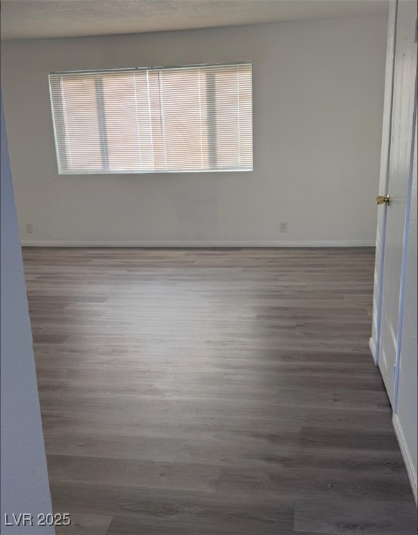 Spare room with baseboards and wood finished floor