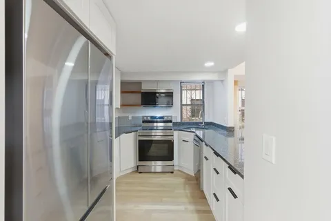 a kitchen with stainless steel appliances granite countertop a refrigerator and a sink