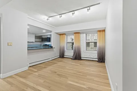 a view of a kitchen with a refrigerator and a stove top oven