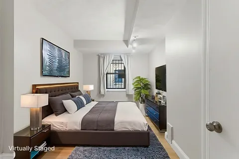 a view of an empty room with window and chandelier fan
