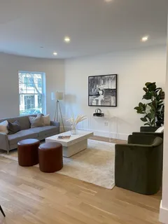 a living room with furniture and a potted plant