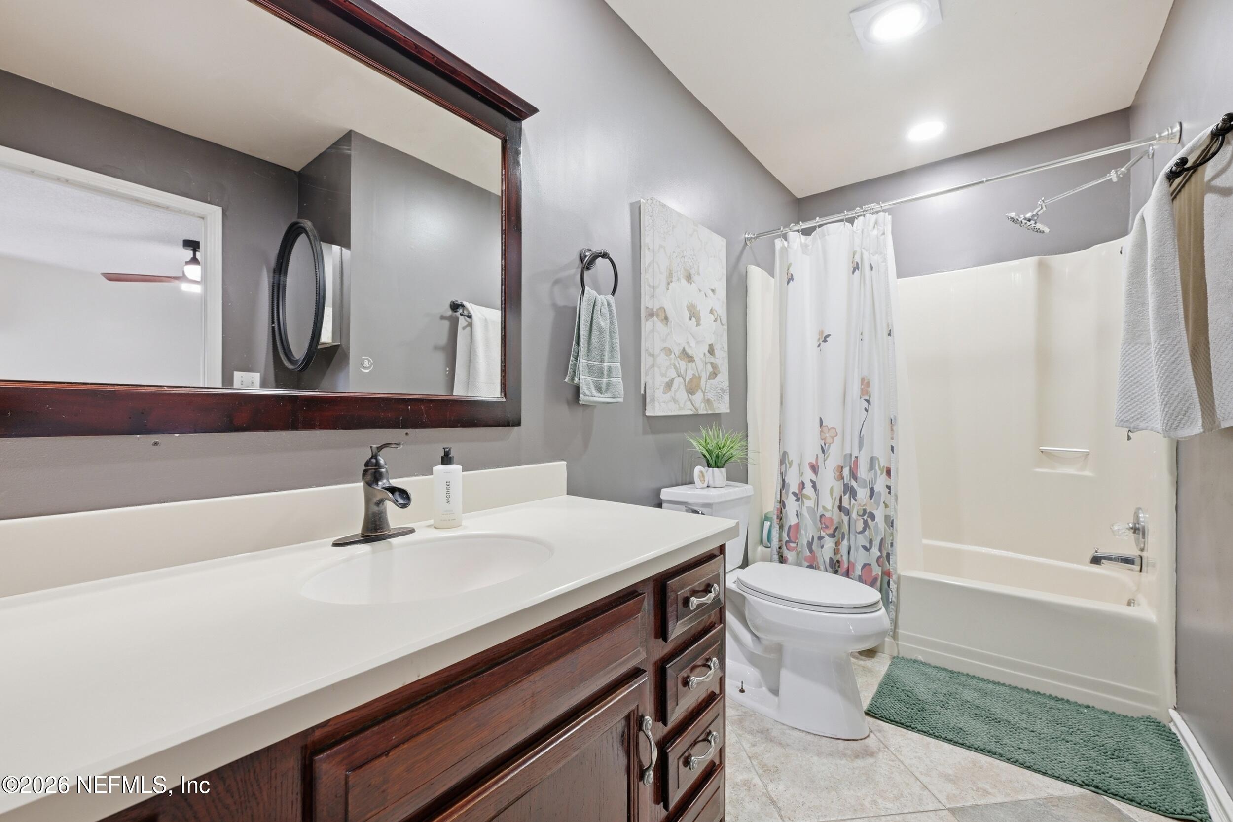 12890 Attrill Road Jacksonville, FL 32258 - Photo 10 of 29 a bathroom with a sink a toilet a mirror a vanity and bathtub