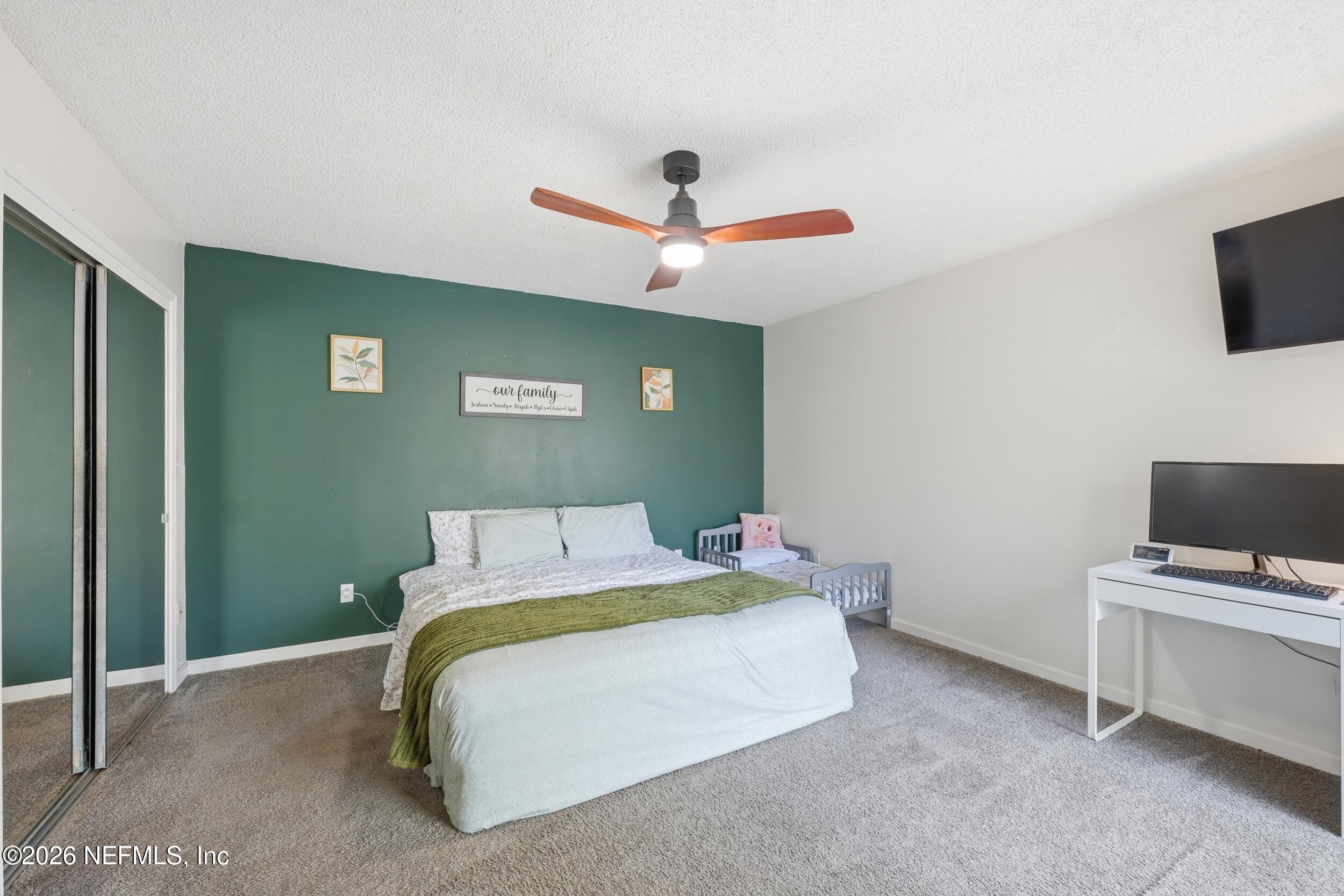 12890 Attrill Road Jacksonville, FL 32258 - Photo 8 of 29 a bedroom with a bed and a flat screen tv