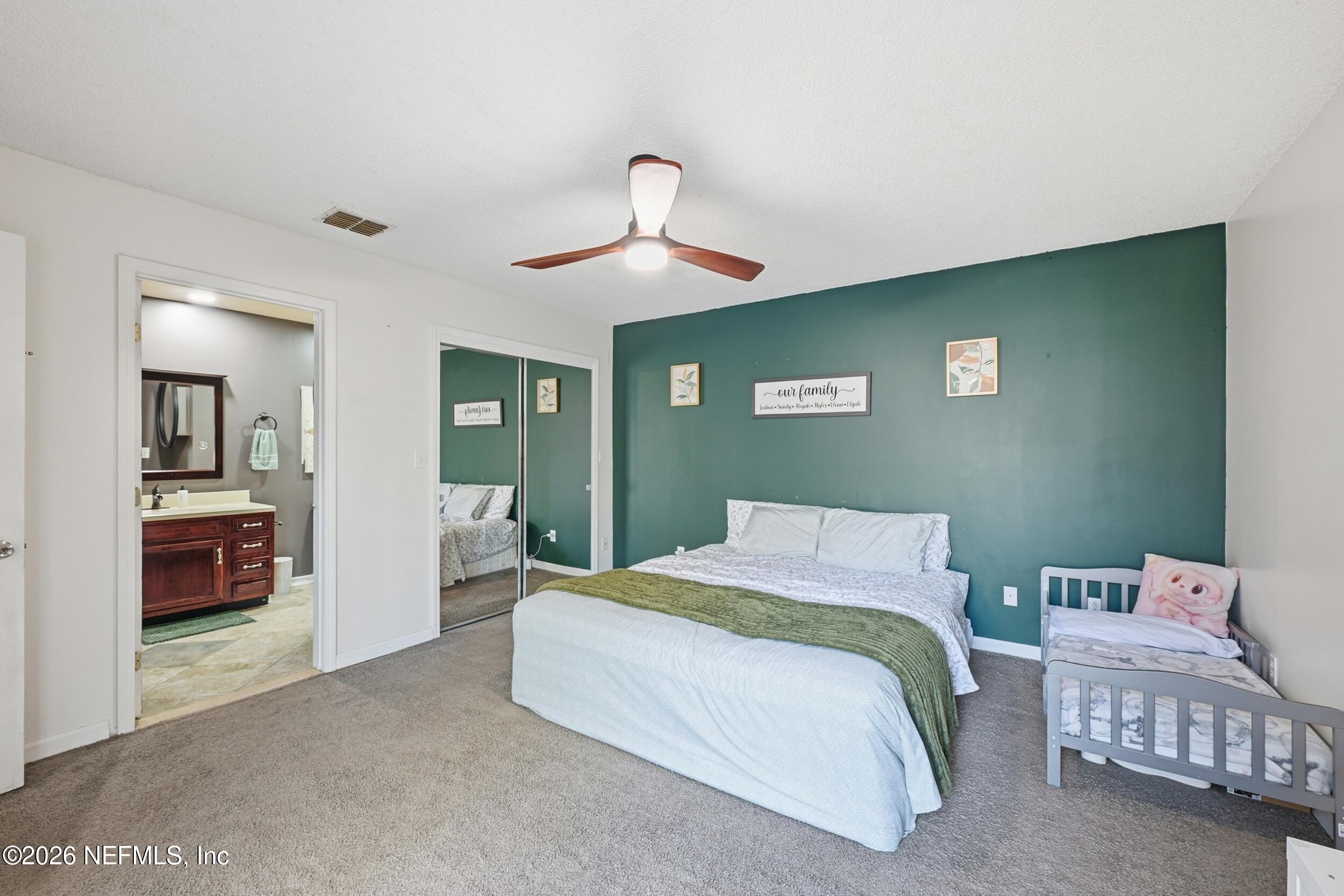 12890 Attrill Road Jacksonville, FL 32258 - Photo 9 of 29 a bedroom with a bed and a chandelier