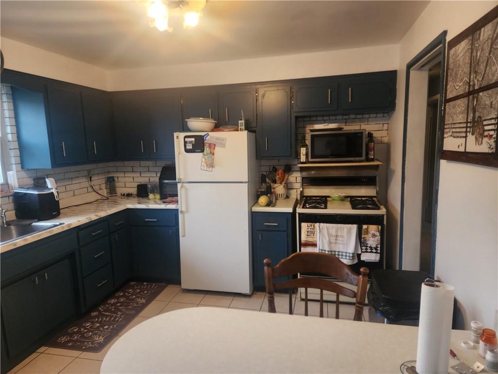 5014 3rd Street McKeesport, PA 15132 - Photo 14 of 28 a kitchen with a refrigerator and a stove top oven
