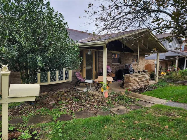 a view of a chair and table in backyard of the house
