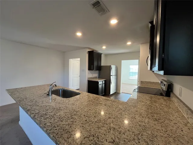 a large kitchen with kitchen island a sink stainless steel appliances and a counter space