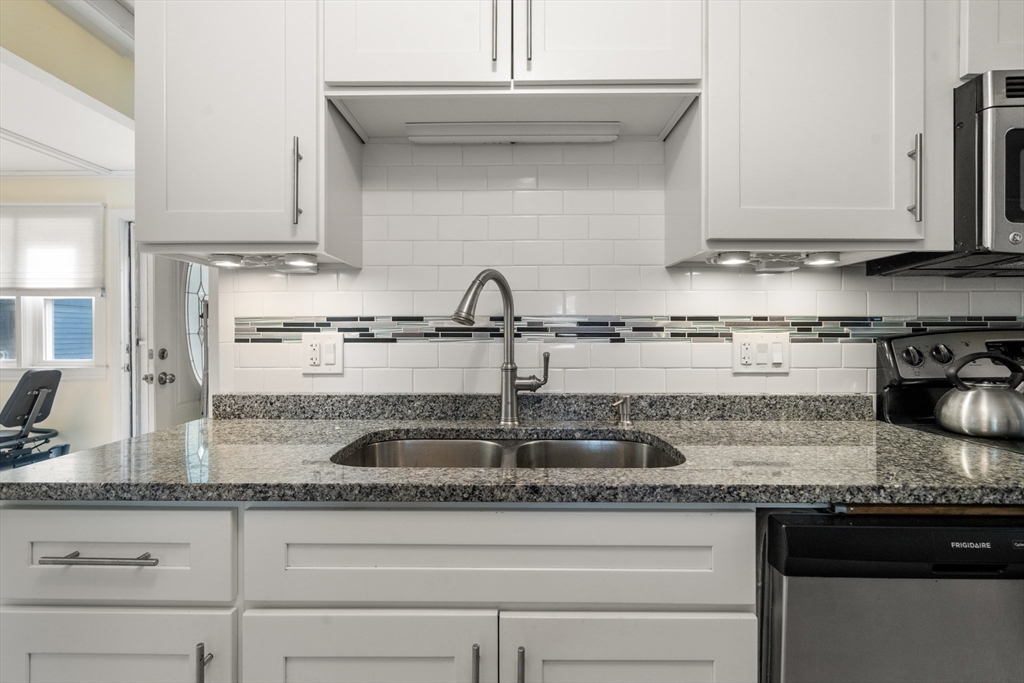 17 Chandler Road Malden, MA 02148 - Photo 11 of 19 a kitchen with granite countertop a sink a stove and cabinets