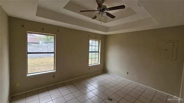 an empty room with windows and fan