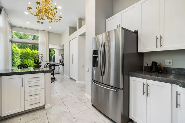 a kitchen with stainless steel appliances granite countertop a refrigerator and a sink