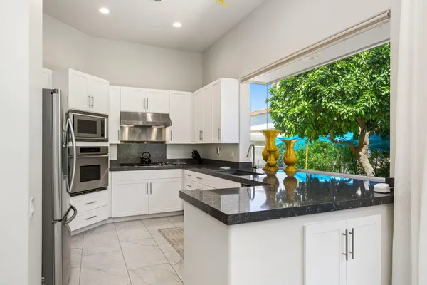 a kitchen with stainless steel appliances kitchen island granite countertop a sink and cabinets