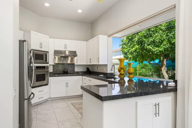 a kitchen with stainless steel appliances kitchen island granite countertop a sink and cabinets