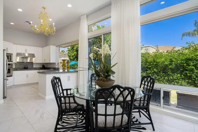 a view of a dining room with furniture a chandelier and wooden floor