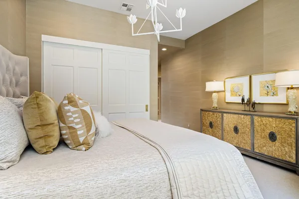 a bedroom with a bed and a chandelier