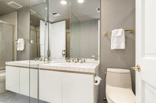 a bathroom with a toilet sink and mirror
