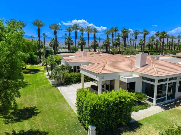 a view of a house with a yard and potted plants