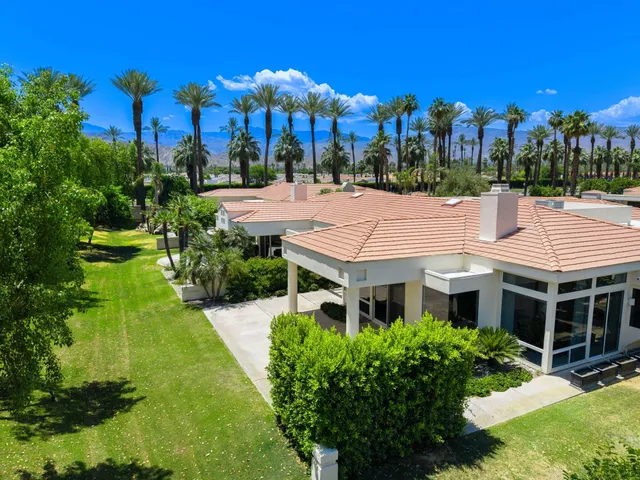 a view of a house with a yard and potted plants