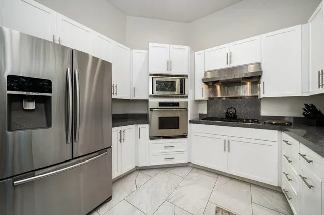 a kitchen with stainless steel appliances and cabinets