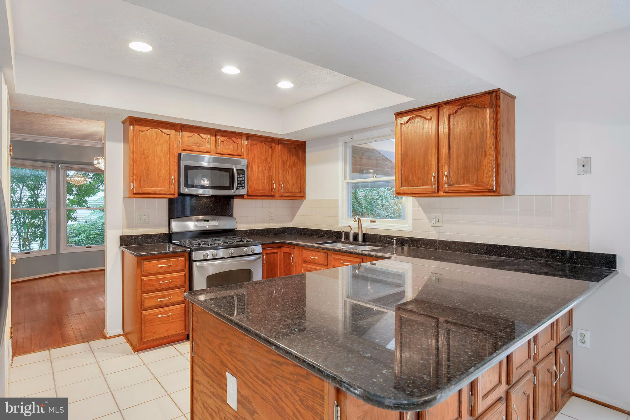 14908 Windmill Terrace Silver Spring, MD 20905 - Photo 6 of 30 a kitchen with stainless steel appliances granite countertop a sink a stove and a microwave