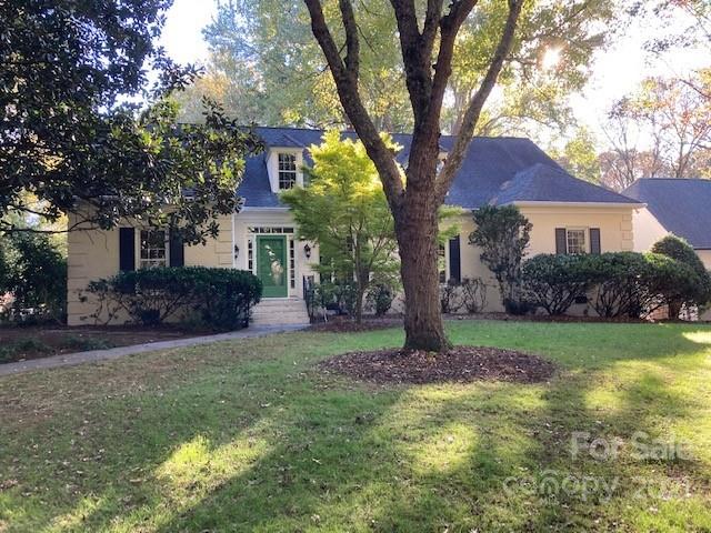 a tree in front of a white house
