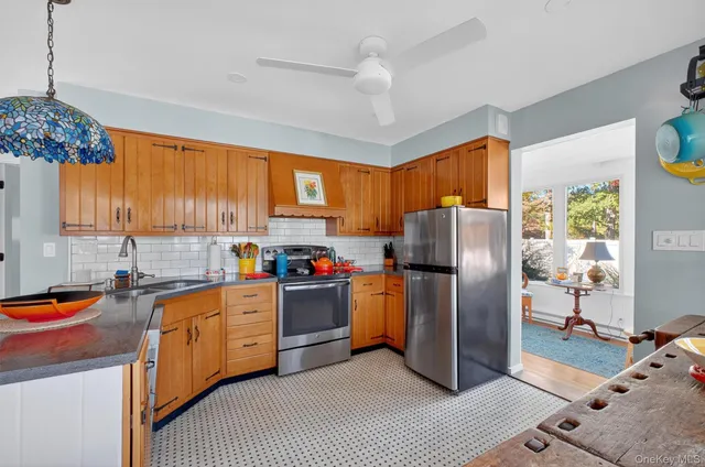 a kitchen with stainless steel appliances granite countertop a refrigerator a sink dishwasher a stove a washer and dryer next to a window