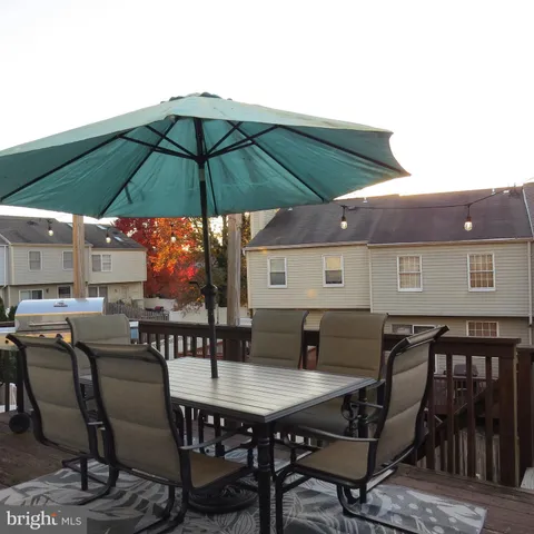 a view of deck with dinning table and chair under an umbrella