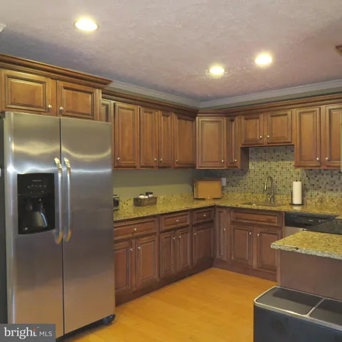 a kitchen with stainless steel appliances granite countertop a refrigerator and a sink