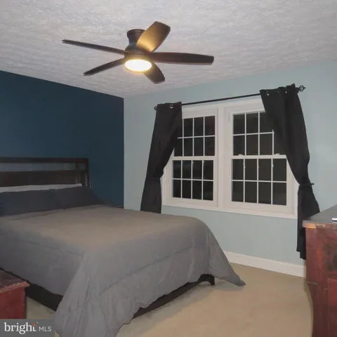 a spacious bedroom with a bed and a large window
