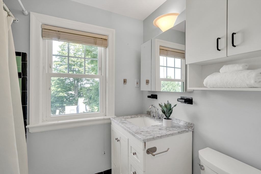 16 Roundwood Road Newton, MA 02464 - Photo 30 of 41 a bathroom with a granite countertop sink and a mirror
