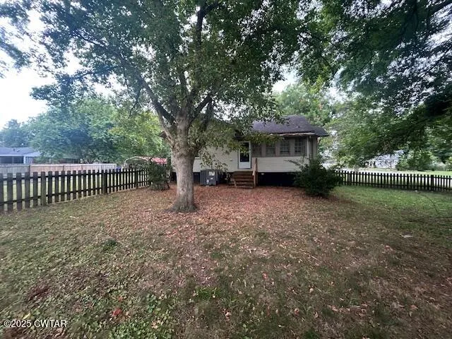 a view of a house with backyard and a trees