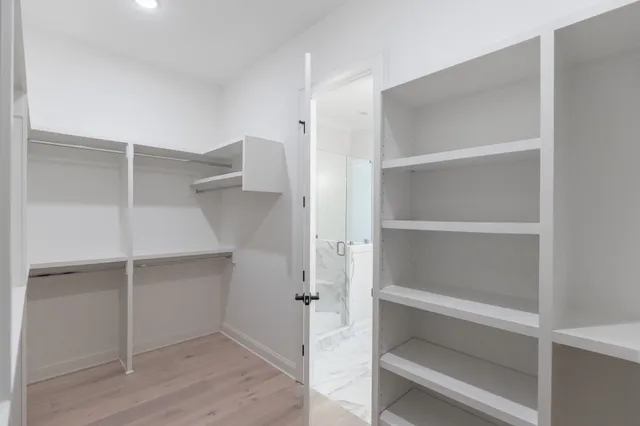 a view of walk in closet with empty racks
