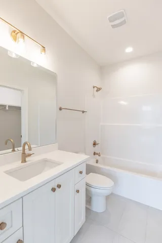 a bathroom with a granite countertop sink a toilet and a large mirror