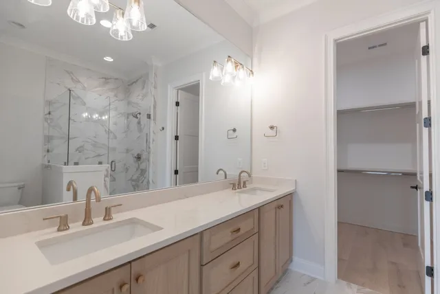 a bathroom with a double vanity sink mirror and shower