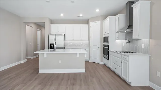 a kitchen with stainless steel appliances a white stove top oven cabinets and a refrigerator