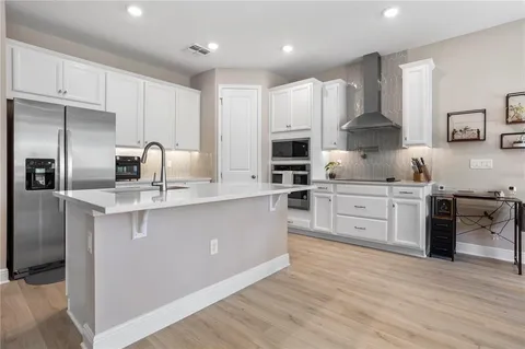 a kitchen with kitchen island granite countertop a sink cabinets and stainless steel appliances