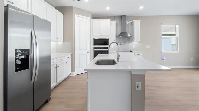 a kitchen with stainless steel appliances granite countertop a refrigerator and a sink